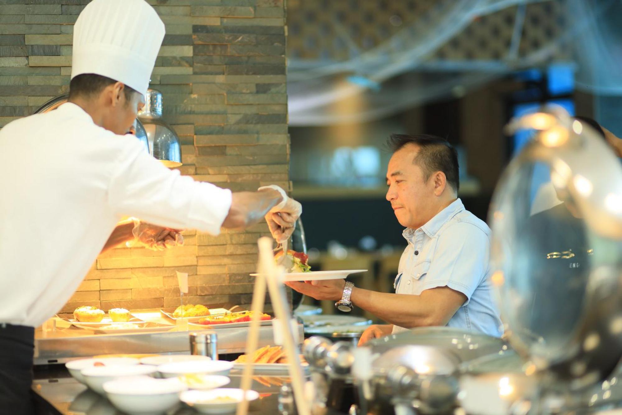 라미 그랜드 호텔 앤 스파 마나마 외부 사진 A chef serving food at a buffet