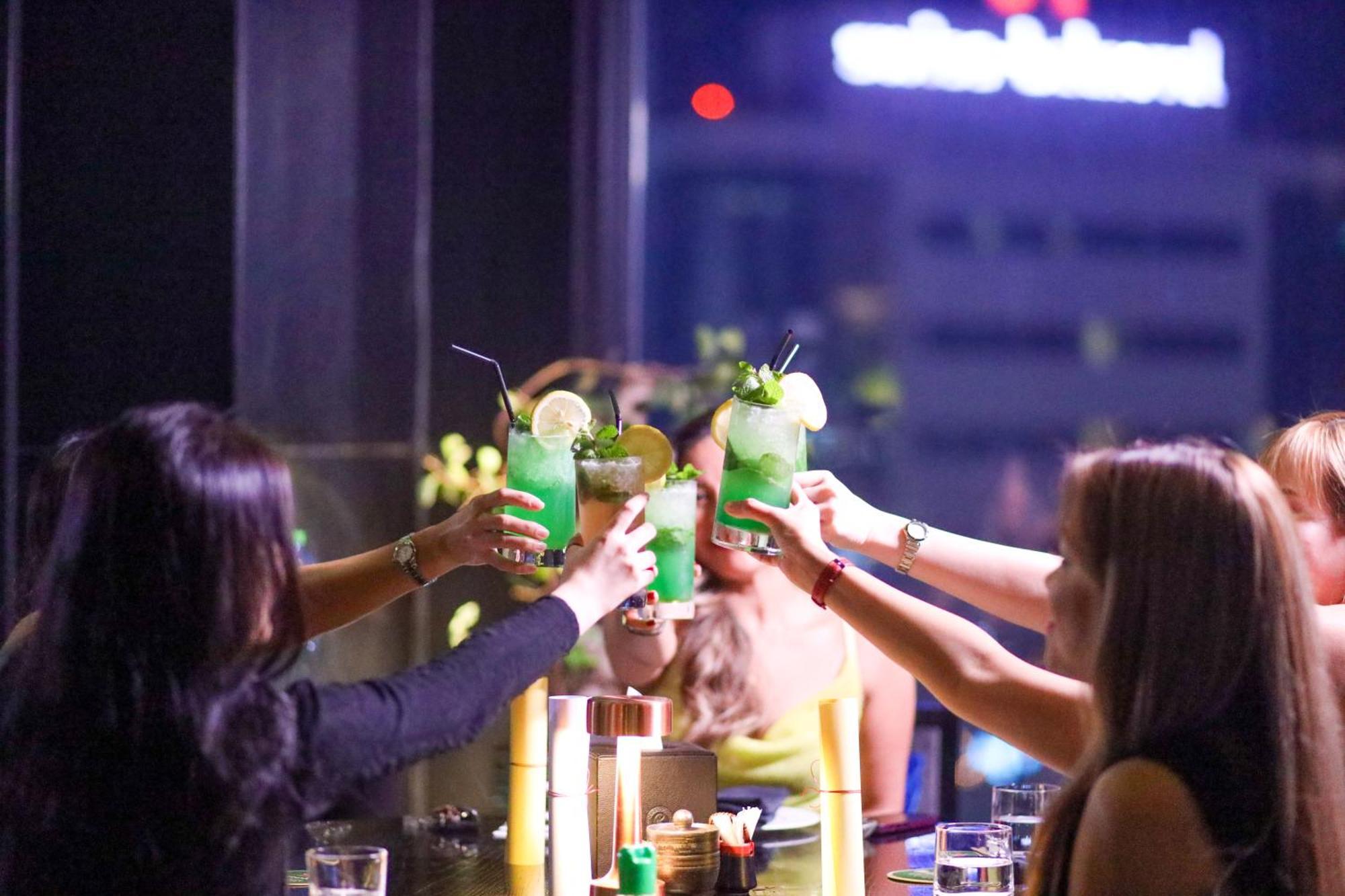 라미 그랜드 호텔 앤 스파 마나마 외부 사진 A group of friends toasting with cocktails